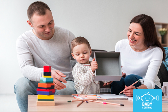 Familia jugando con un bebé mediante colores y juegos educativos para favorecer el desarrollo infantil y la confianza entre escuela y familias.