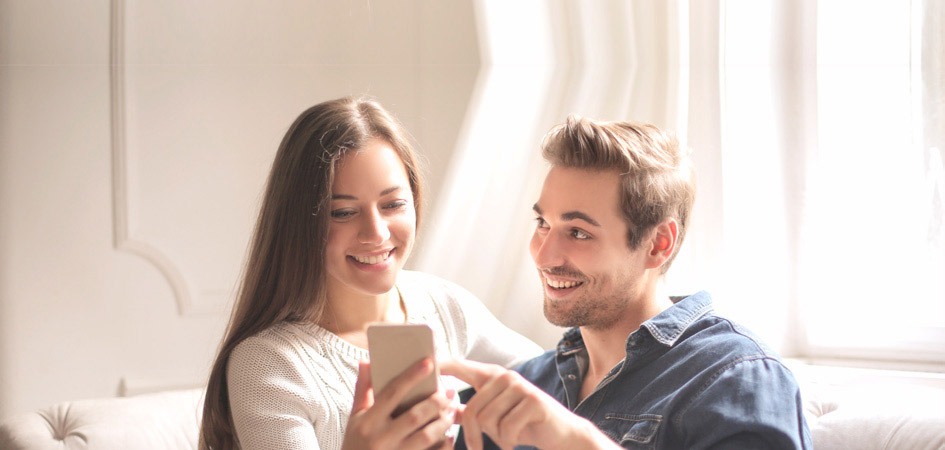 Padres mirando la App para guarderías y escuelas infantiles Baby Control